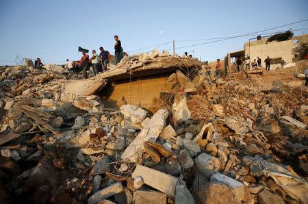 Palestinians stand atop the rubble of a house which was destroyed by Israeli troops during an Israeli raid in the West Bank city of Jenin September 1, 2015. REUTERS/Mohamad Torokman