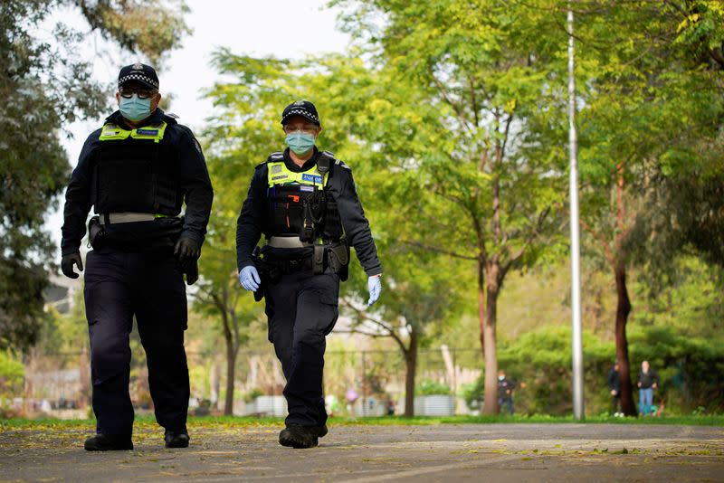 Police officers patrol the grounds outside a public housing tower, reopened following a COVID-19 lockdown, in Melbourne