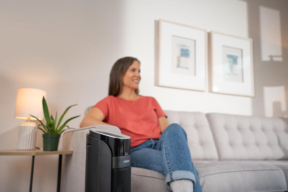 Woman enjoying clean indoor air with her Noma air purifier