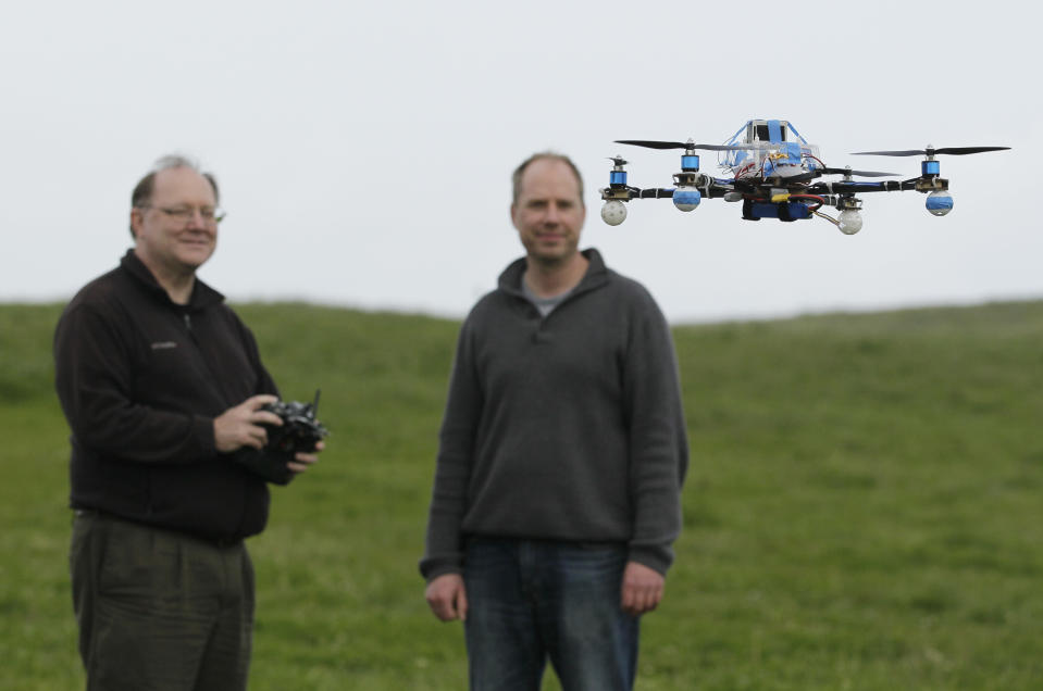 In this March, 28, 2012, photo, Mark Harrison, left, pilots an Arcti Copter 5 drone as Andreas Oesterer, right, watches at a waterfront park in Berkeley, Calif. Interest in the domestic use of drones is surging among public agencies and private citizens alike, including a thriving subculture of amateur hobbyists, even as the prospect of countless tiny but powerful eyes circling in the skies raises serious privacy concerns. (AP Photo/Eric Risberg)