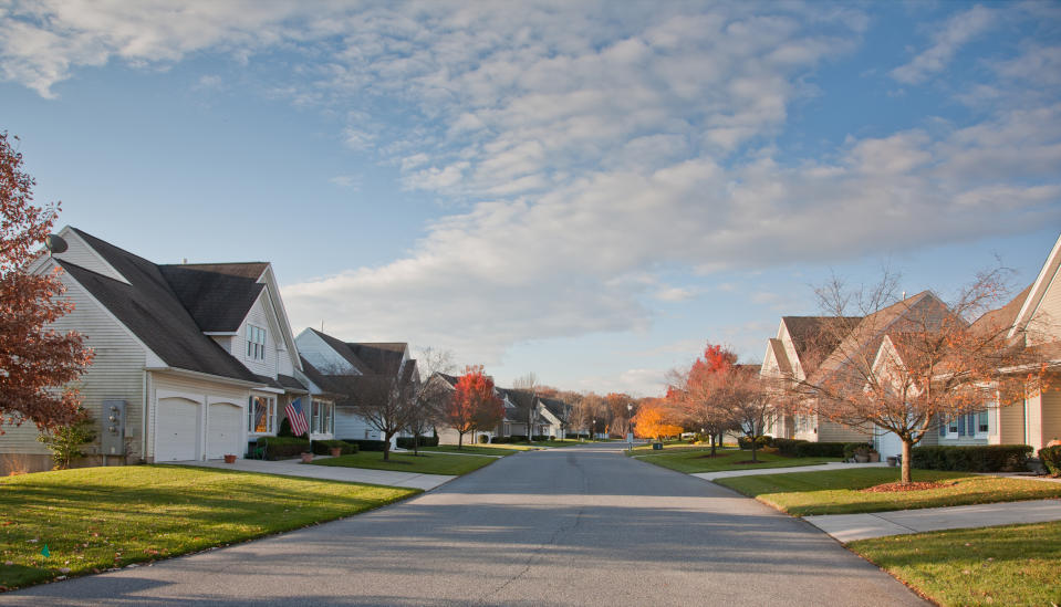 Suburban street with rows of similar houses, clear sky, perfect for a peaceful neighborhood stay