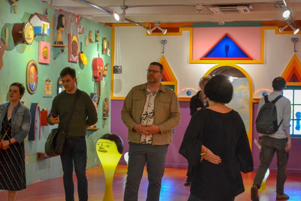 Men and women stand in a room looking at art at the Mattress Factory in Pittsburgh, Pennsylvania