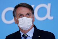 FILE PHOTO: Brazil's President Jair Bolsonaro wearing a protective mask looks on during the launching ceremony of the Plano Safra 2020/2021, action plan for the agricultural sector, in Brasilia