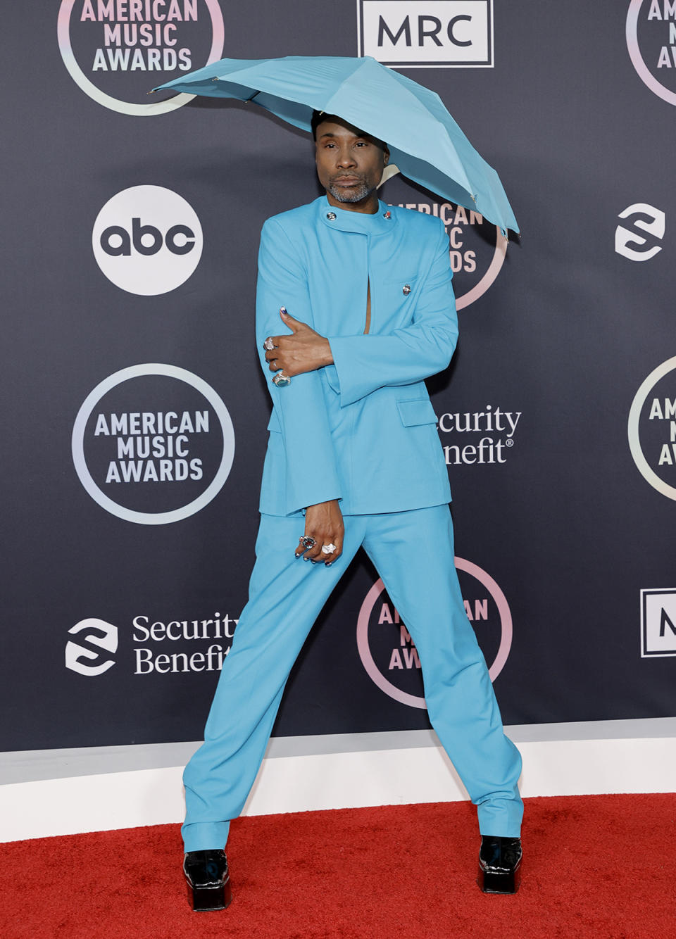 Billy Porter wears a blue suit and umbrella hat at the 2021 American Music Awards at Microsoft Theater on November 21, 2021 in Los Angeles, California. (Photo by Amy Sussman/Getty Images)