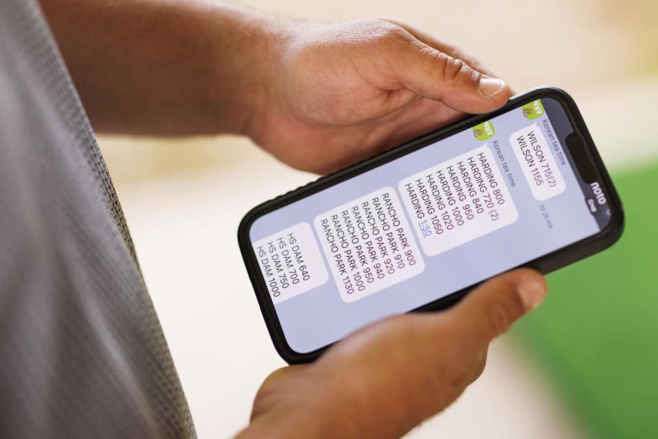 Dave Fink, a golf teaching pro, shows a screenshot of a course broker's available tee times on the KakaoTalk app.