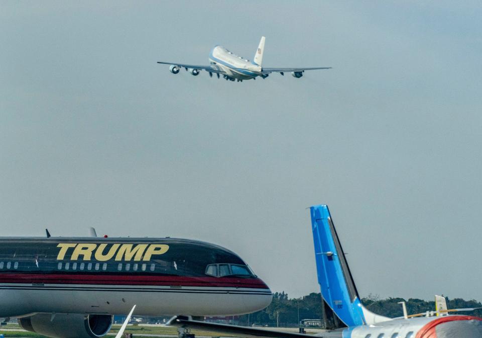 President Joe Biden leaves aboard Air Force One past Donald Trump's plane at Palm Beach International Airport after a campaign reception in Jupiter on January 30, 2024 in West Palm Beach, Florida.