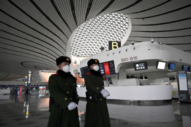 Paramilitary police officers wearing face masks walk past a terminal hall at the Beijing Daxing International Airport, as the country is hit by an outbreak of the novel coronavirus, in Beijing