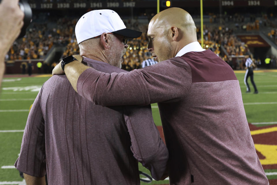 New Mexico State coach Jerry Kill, left, and Minnesota head coach P. J. Fleck, right, embrace after Minnesota defeated New Mexico State 38-0 in an NCAA college football game Thursday, Sept. 1, 2022, in Minneapolis. (AP Photo/Abbie Parr)