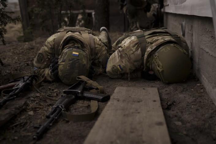 Ukrainian soldiers take cover from incoming artillery fire in Irpin, the outskirts of Kyiv, Ukraine, Sunday, March 13, 2022. (AP Photo/Felipe Dana)