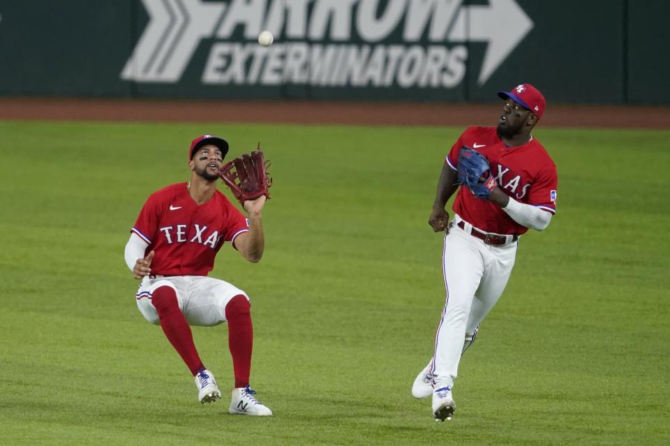 Texas Rangers center fielder Leody Taveras, left, waits to catch a fly ball hit by Chicago White Sox's Billy Hamilton as right fielder Adolis Garcia watches during the fifth inning of a baseball game in Arlington, Texas, Friday, Sept. 17, 2021. (AP Photo/Tony Gutierrez)