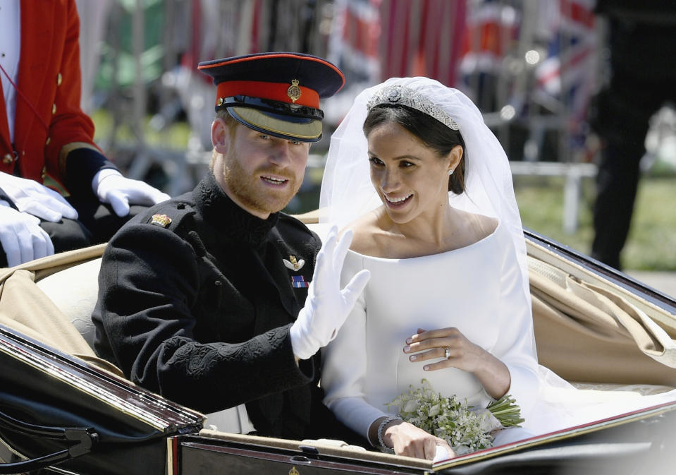The royal couple wave to the crowds from their horse-drawn carriage. Source: Jeff J Mitchell/pool photo via AP