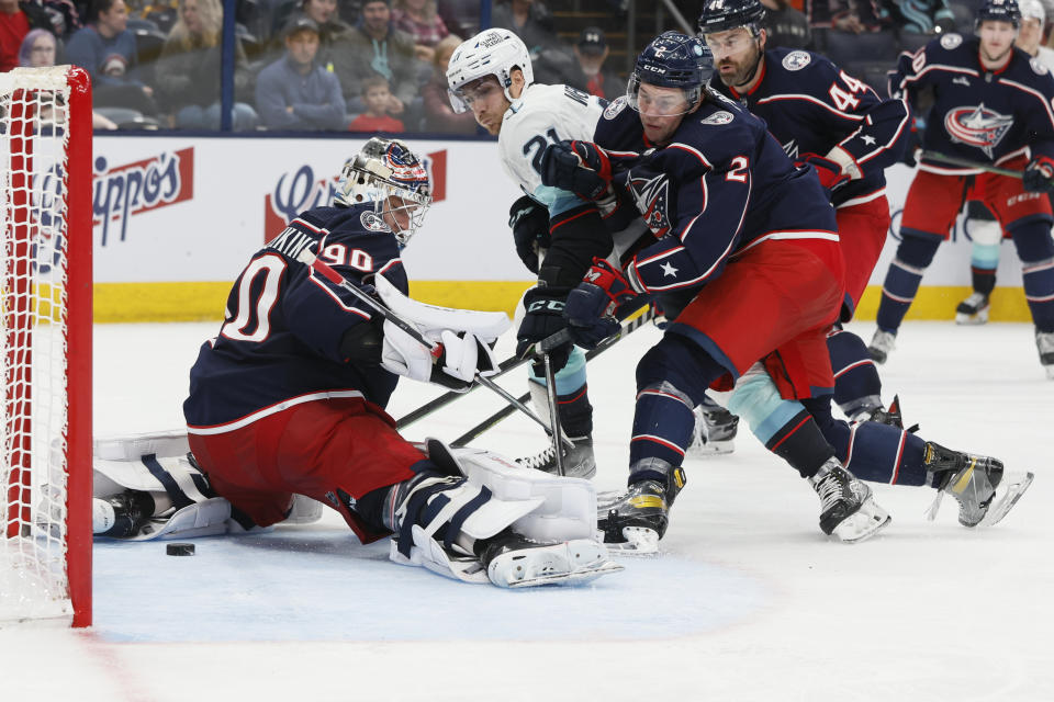Seattle Kraken's Alex Wennberg (21) scores against Columbus Blue Jackets' Elvis Merzlikins, left, as Andrew Peeke, right front, defends during the third period of an NHL hockey game Friday, March 3, 2023, in Columbus, Ohio. (AP Photo/Jay LaPrete)