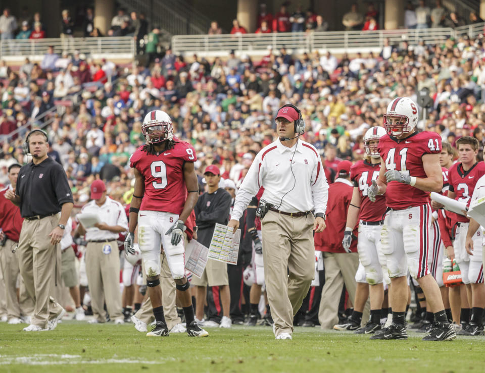 PALO ALTO, CA - NOVEMBER 24:  Jim Harbaugh, head coach of the Stanford Cardinal, watchs from the sidelines during an NCAA football game against the Notre Dame Irish played on November 24, 2007 at Stanford Stadium in Palo Alto, California.  Visible players include Richard Sherman #9 and Tom McAndrew #41.    (Photo by David Madison/Getty Images) 
