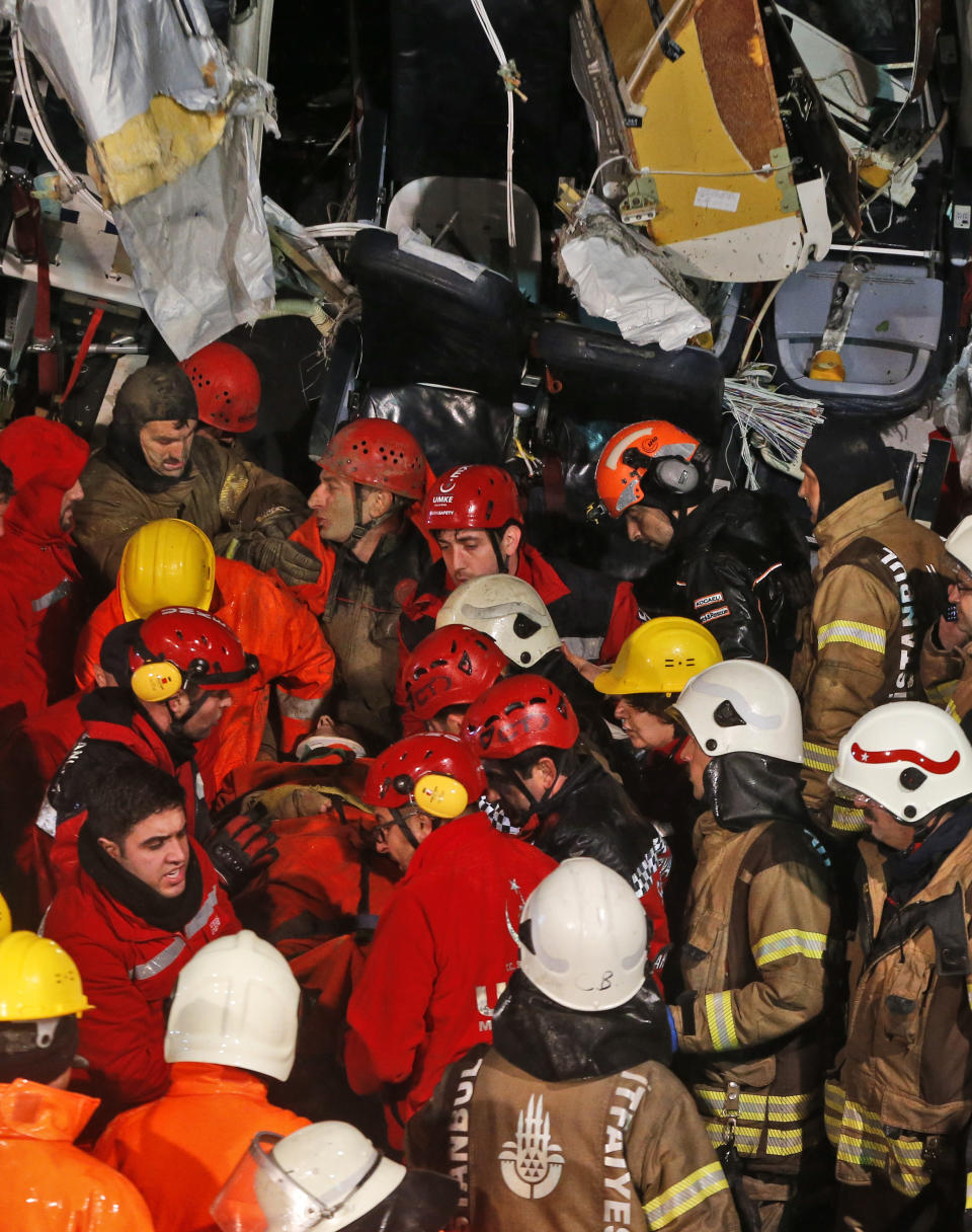 Rescue members evacuate an injured person from the wreckage of a plane after it skidded off the runway at Istanbul's Sabiha Gokcen Airport, in Istanbul, Wednesday, Feb. 5, 2020. The plane skidded off as it tried to land in bad weather, crashing into a field and breaking into pieces. Passengers had to evacuate through cracks in the smashed plane and authorities said 120 people were sent to the hospital with injuries. (AP Photo/Emrah Gurel)