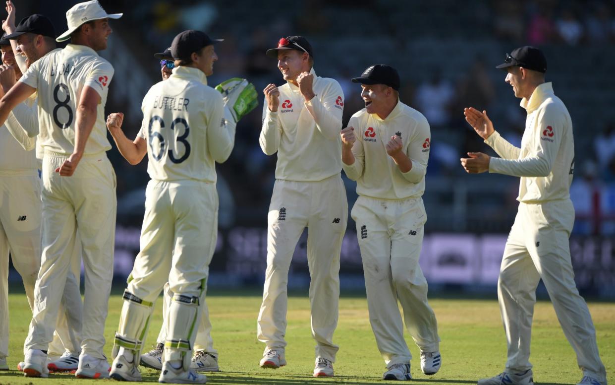 England captain Joe Root and Ollie Pope celebrate after bowler Chris Woakes had taken the wicket of Faf du Plessis - Getty Images Europe