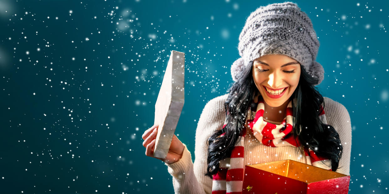 Happy young woman opening a Christmas present box