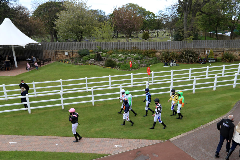 <p>REDCAR, ENGLAND - MAY 17: Jockeys make their way towards the parade ring before the Watch Racing TV In Stunning HD Handicap at Redcar Racecourse on May 17, 2021 in Redcar, England. (Photo by Mike Egerton-Pool/Getty Images)</p>
