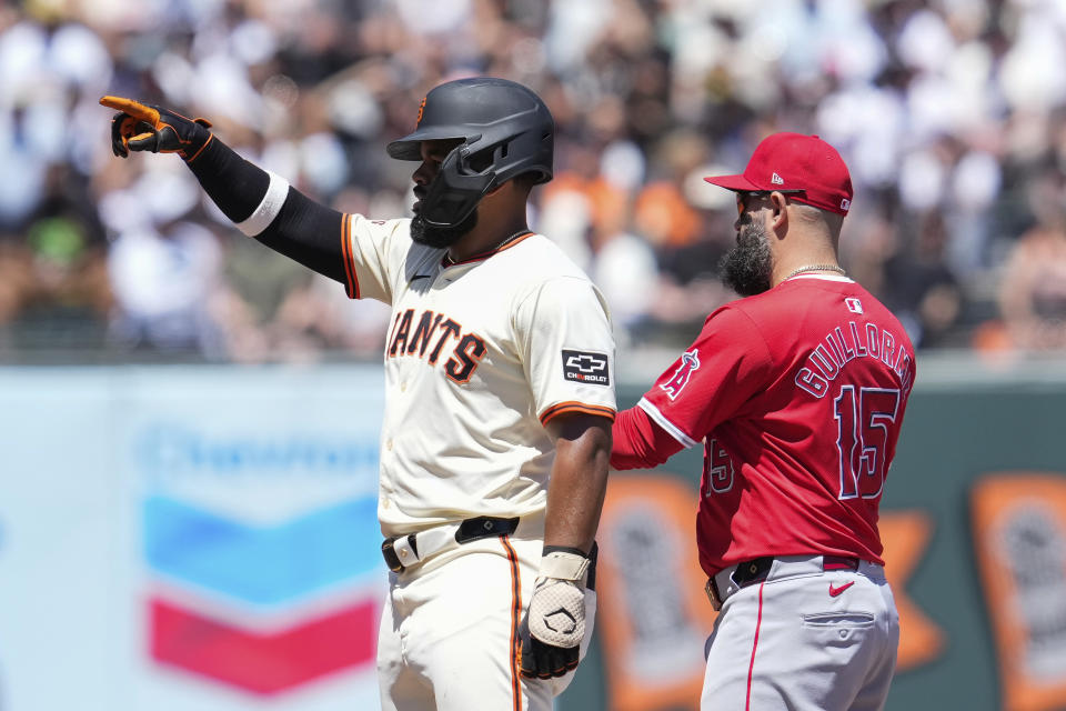 San Francisco Giants' Heliot Ramos, left, reacts next to Los Angeles Angels second baseman Luis Guillorme after hitting an RBI double during the fifth inning of a baseball game Saturday, June 15, 2024, in San Francisco. (AP Photo/Godofredo A. Vásquez)