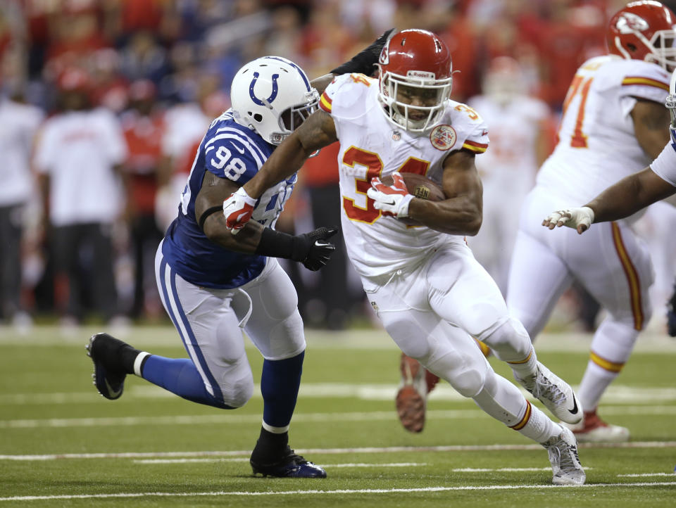 Kansas City Chiefs running back Knile Davis (34) runs from Indianapolis Colts outside linebacker Robert Mathis (98) during the first half of an NFL wild-card playoff football game Saturday, Jan. 4, 2014, in Indianapolis. (AP Photo/AJ Mast)