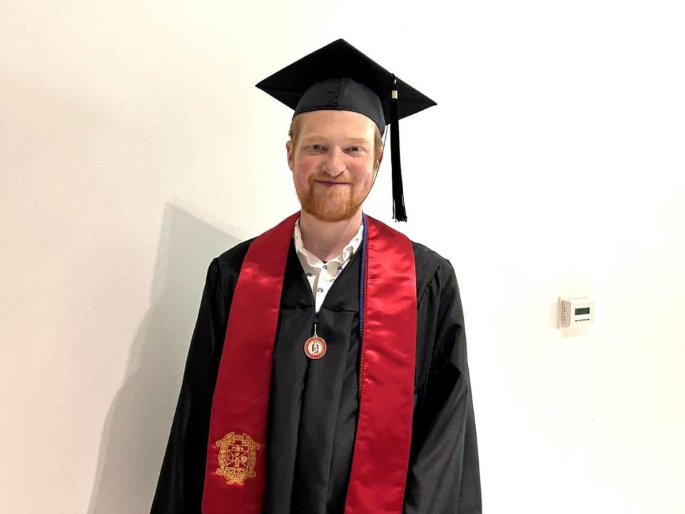 Grant Martin poses in his cap and gown at the special graduation ceremony Columbus State University conducted for him May 25, 2024, at Emory University Hospital in Atlanta, where he is waiting for a heart transplant.