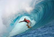 FILE PHOTO: Surfer Slater of the U.S rides a wave during the third round of competition in the Billabong Pro surfing tournament on the legendary reef break in Teahupoo
