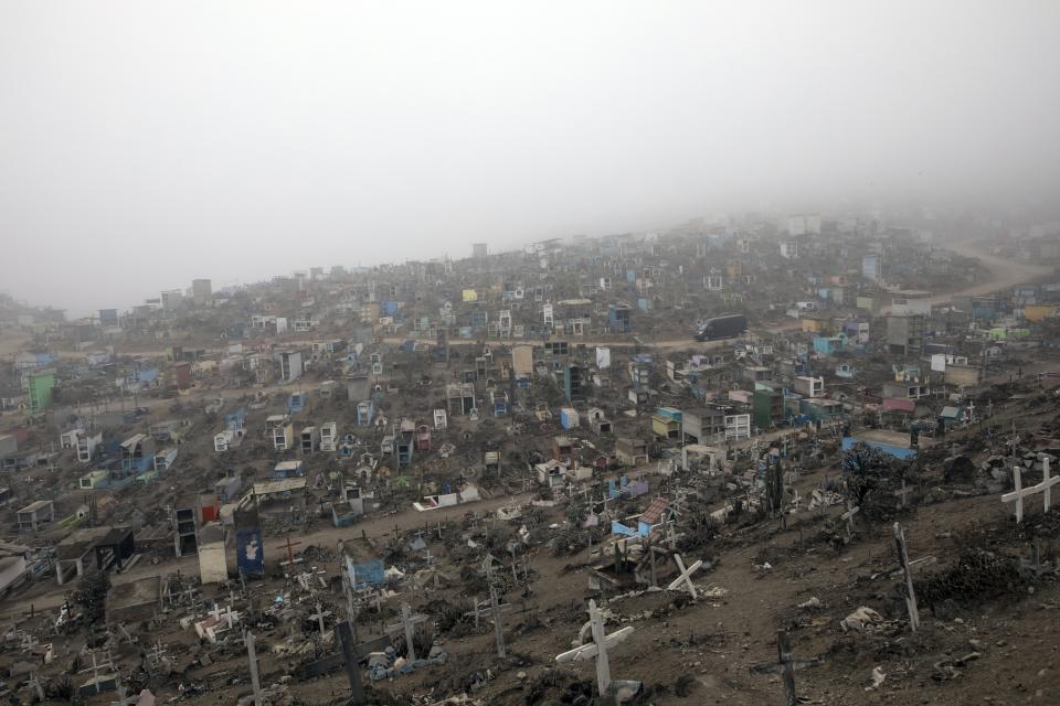 A funeral home vehicle carrying COVID-19 victims drives amid tombs on a road inside Nueva Esperanza cemetery, in the outskirts of Lima, Peru, Tuesday, May 26, 2020. (AP Photo/Rodrigo Abd)