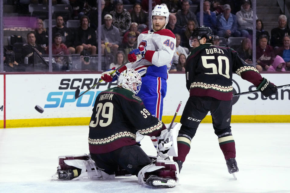 Montreal Canadiens right wing Joel Armia (40) sends the puck wide of Arizona Coyotes goaltender Connor Ingram (39) as Coyotes defenseman Sean Durzi (50) watches during the second period of an NHL hockey game Thursday, Nov. 2, 2023, in Tempe, Ariz. (AP Photo/Ross D. Franklin)