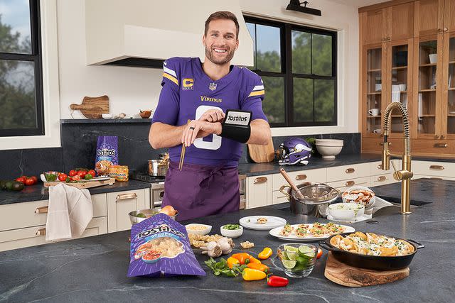 <p>Tostitos</p> Kirk Cousins preps snacks in the kitchen with Tostitos.