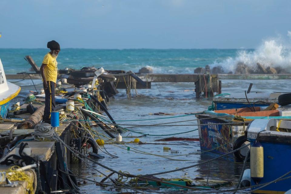 <p>A fisherman looks out at vessels damaged by Hurricane Beryl at the Bridgetown Fisheries in Barbados</p> (AP)