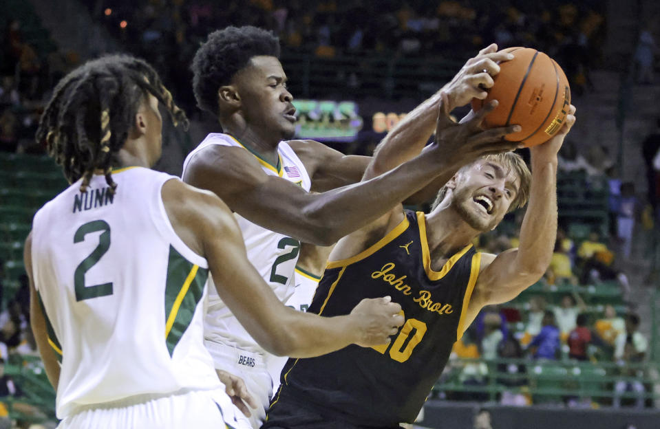 John Brown guard Malachi Reeves, right, battles Baylor center Yves Missi for a loose ball in the first half of an NCAA college basketball game, Thursday, Nov. 9, 2023, in Waco, Texas. (AP Photo/Rod Aydelotte)