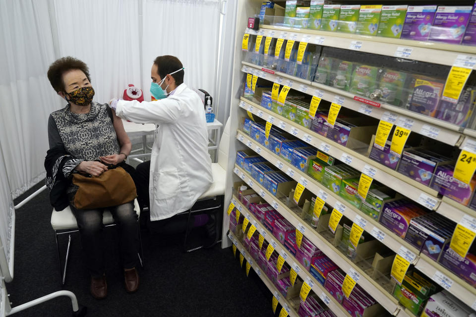 Pharmacist Todd Gharibian, right, administers a dose of the Moderna COVID-19 vaccine to Toshiko Sugiyama, left, at a CVS Pharmacy branch Monday, March 1, 2021, in Los Angeles. (AP Photo/Marcio Jose Sanchez)