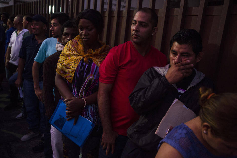 Migrants wait in line outside the Mexican Commission for Migrant Assistance office to get the documents needed that allows them to stay in Mexico, in Tapachula, Thursday, June 20, 2019. The flow of migrants into southern Mexico has seemed to slow in recent days as more soldiers, marines, federal police, many as part of Mexico's newly formed National Guard, deploy to the border under a tougher new policy adopted at a time of increased pressure from the Trump administration. (AP Photo/Oliver de Ros)