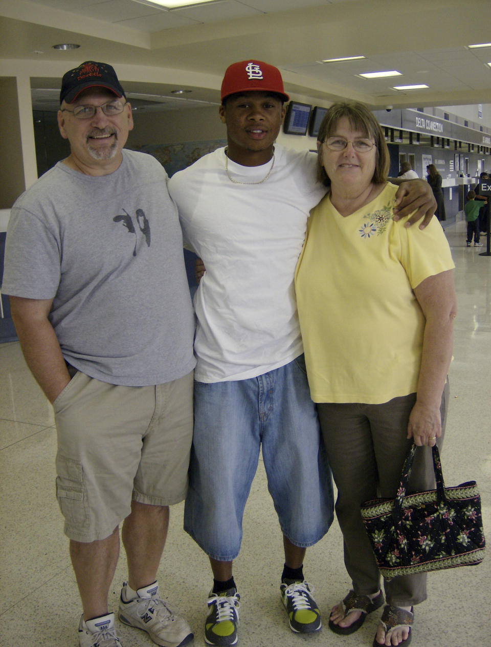 In this photo provided by TeriAnn Reynolds, minor league baseball player hosts Pat and Tina Kiernan flank minor league baseball player Adron Chambers, at the end of the season at the airport in Blountville, Tenn., in August 2007. (Photo courtesy TeriAnn Reynolds via AP)