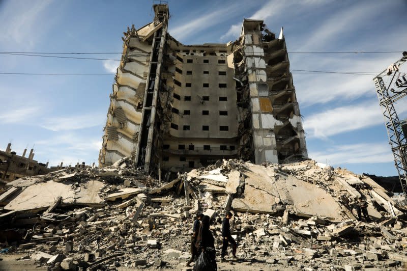 Palestinians walk amid rubble of a residential building hit in an overnight Israeli airstrike in Rafah in the southern Gaza Strip on Saturday. Photo by Ismael Mohamad/UPI