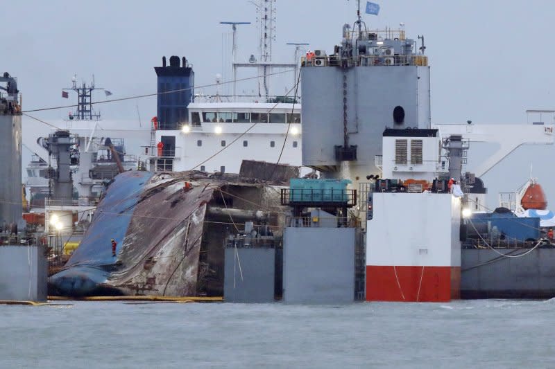 2014年4月16日發生沉船慘劇的南韓渡輪世越號（Sewol），25日被抬至半潛船上，打撈作業基本成功。（AP）