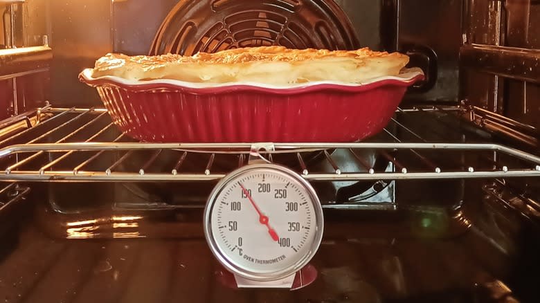oven thermometer in oven with pie