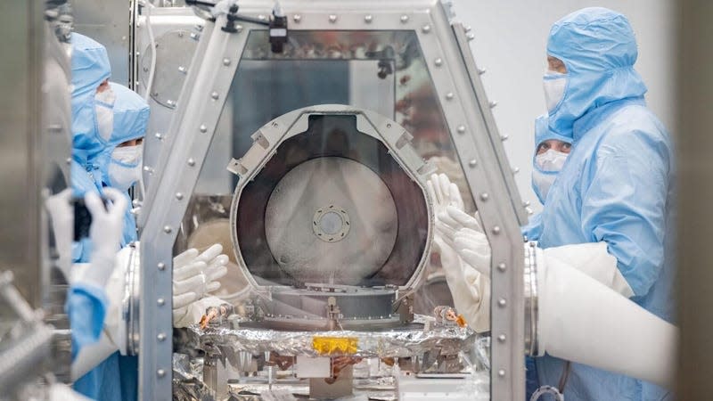 NASA curation team members along with Lockheed Martin recovery specialists removing the canister lid. 