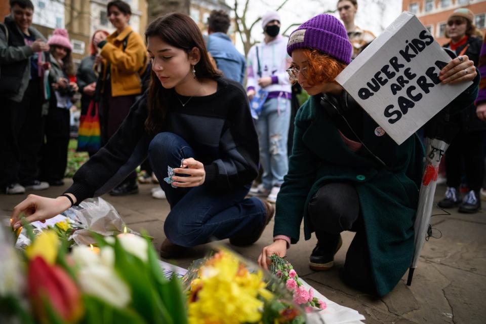 People gather to listen to speeches and lay floral tributes in Soho Square, central London, during a vigil (Getty)