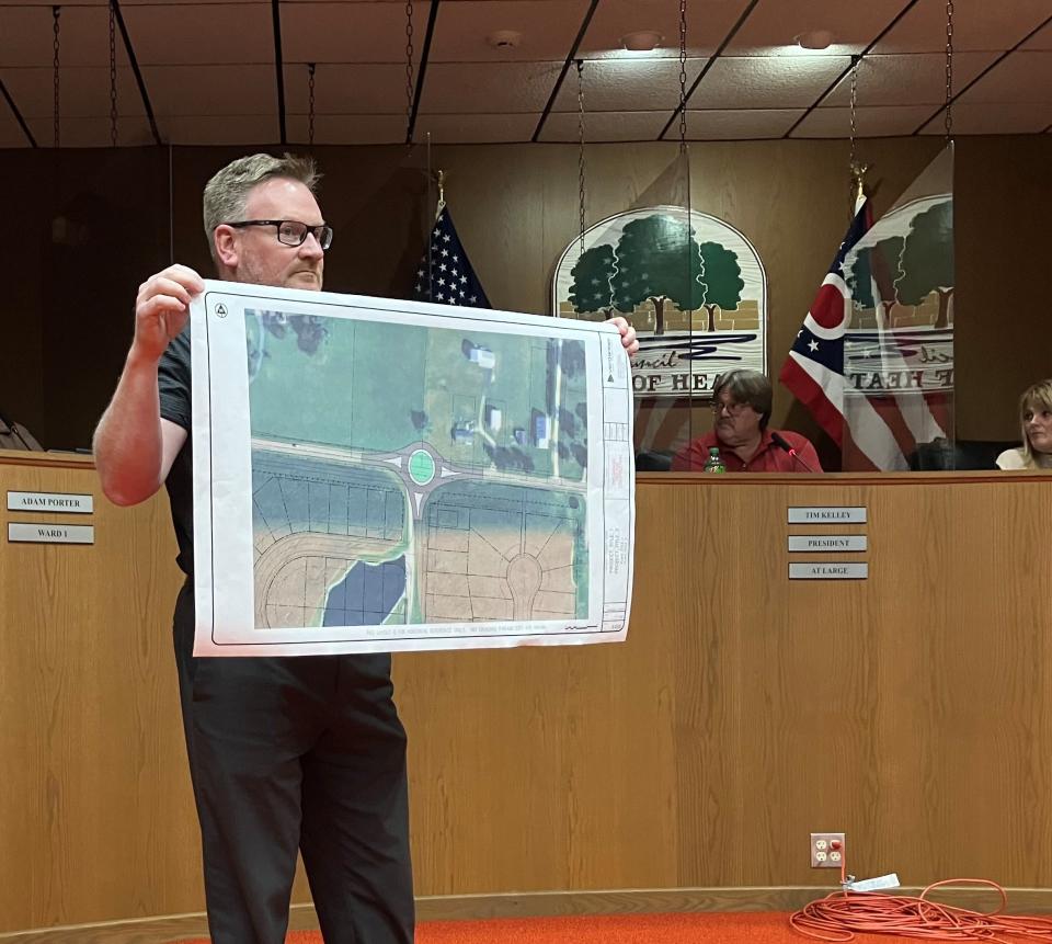 Jared Lane, the Heath building and zoning director, holds up a map showing the location of a proposed roundabout on Irving Wick Drive East.