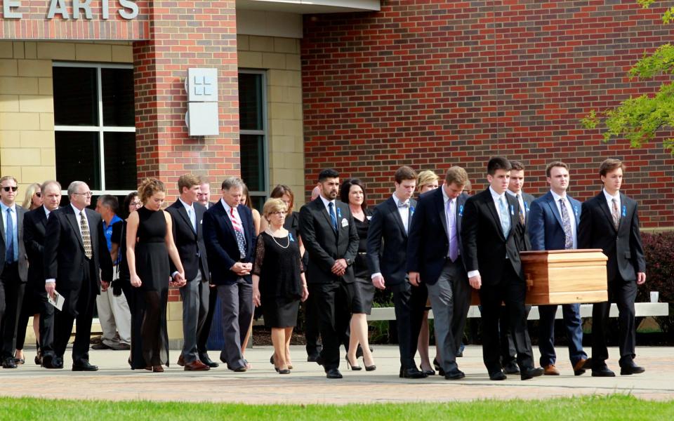 The casket of Otto Wambire is carried to the hearse followed by his family and friends after a funeral service for Warmbier, who died after his release from North Korea, at Wyoming High School in Wyoming. - Credit: Reuters