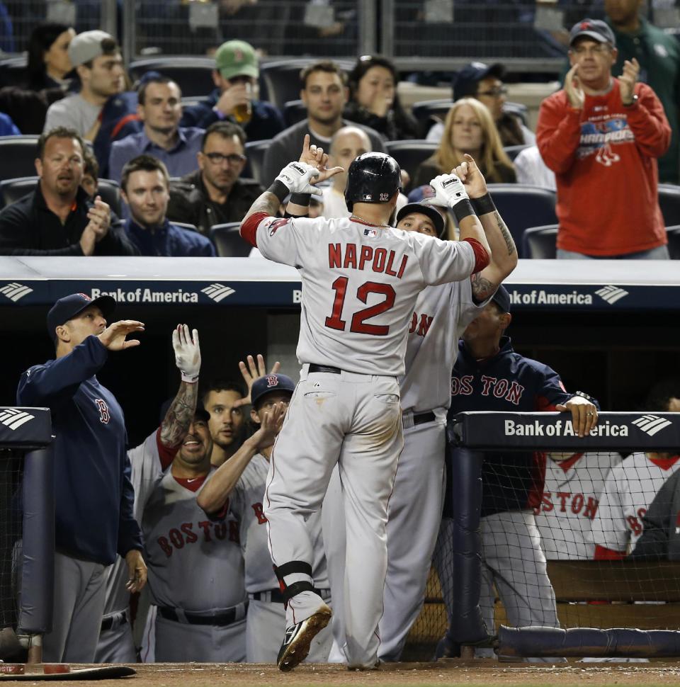 Teammates congratulate Boston Red Sox Mike Napoli (12) after he hit a sixth-inning solo home run off New York Yankees starting pitcher Ivan Nova in a baseball game at Yankee Stadium in New York, Sunday, April 13, 2014. (AP Photo/Kathy Willens)