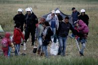 A migrant family carries their belongings during the evacuation by police of a makeshift camp at the Greek-Macedonian border near the village of Idomeni, on May 24, 2016