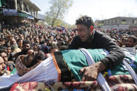 A relative of Umer Farooq, a Kashmiri civilian who was killed Sunday cries over his body during his funeral at Baroosa village 34 Kilometers (21 miles) northeast of Srinagar, Indian controlled Kashmir, Monday, April 10, 2017. Government forces opened fire on Sunday on crowds of people who attacked polling stations during a by-election for a vacant seat in India's Parliament, killing eight people. (AP Photo/Mukhtar Khan)