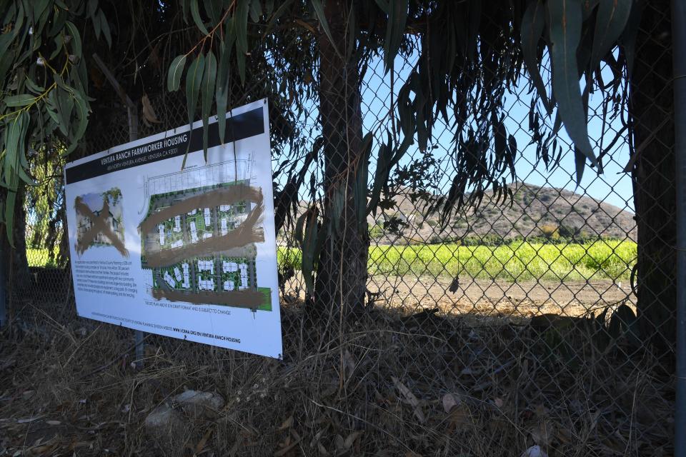 A defaced site plan hangs on the fence of a field along North Ventura Avenue between Ventura and Ojai on Dec. 12. A farmworker housing development is being proposed on property.
