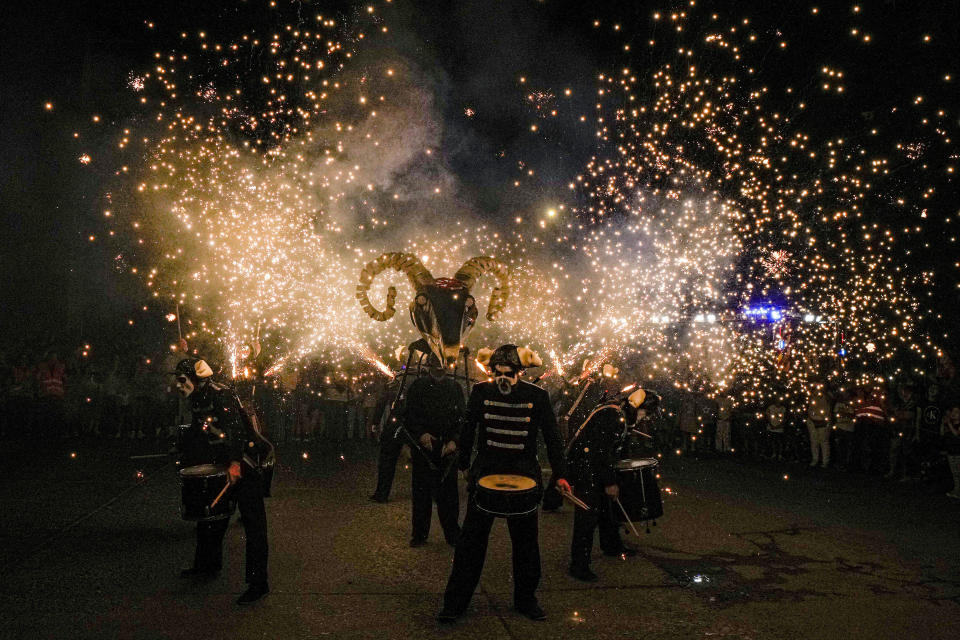 Miembros del grupo vasco "Deabru Beltzak", durante un espectáculo con el demonio Aker, tambores, música y fuegos artificiales, en Santiago, Chile, el 20 de enero de 2024. (AP Foto/Esteban Félix)