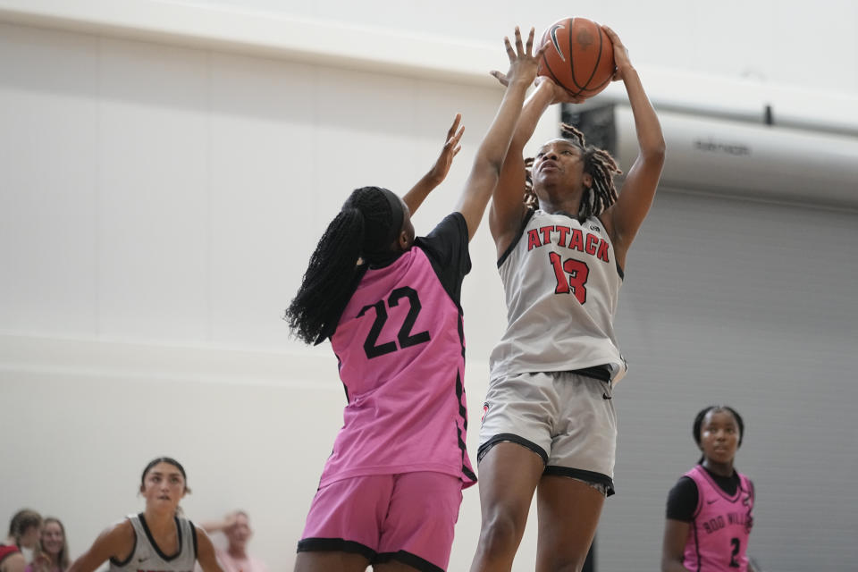 Iowa Attack guard Divine Bourrage, right, shoots over a Boo Williams player during a game at the NCAA College Basketball Academy, Friday, July 28, 2023 in Memphis, Tenn. The transfer portal and Name, Image and Likeness (NIL) rules that have engulfed college sports have further complicated the already confusing recruiting process for thousands of teenagers. (AP Photo/George Walker IV)