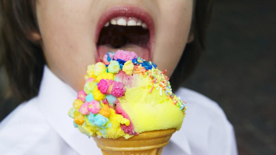 Un niño toma un helado.