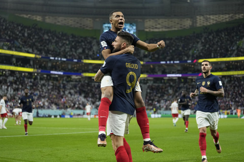 France's Olivier Giroud celebrates with France's Kylian Mbappe, after scoring the opening goal during the World Cup round of 16 soccer match between France and Poland, at the Al Thumama Stadium in Doha, Qatar, Sunday, Dec. 4, 2022. (AP Photo/Ebrahim Noroozi)