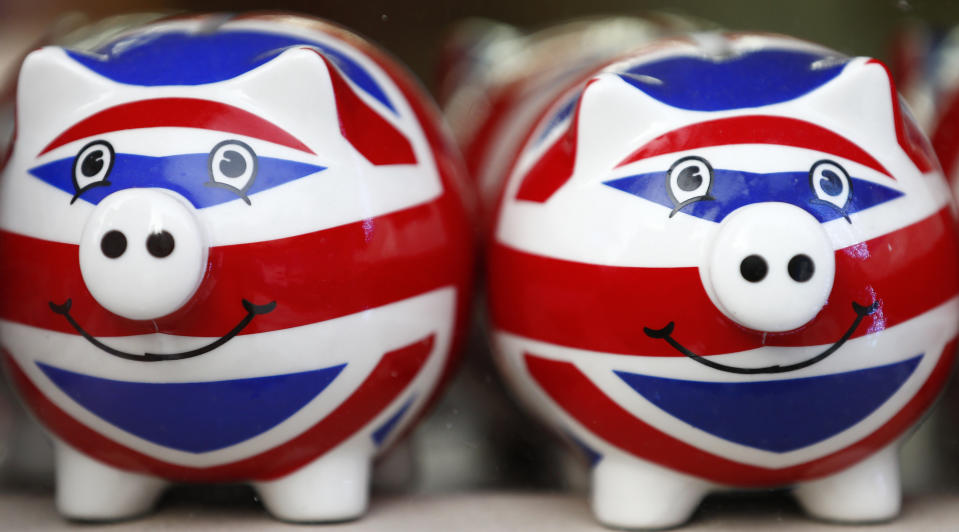 Smiling Union Jack piggy banks are lined up for sale in the window of a souvenir store on Oxford Street in central London January 20, 2014. Britain's financial services industry is beginning to feel the benefits of economic recovery, as firms report growth in profits, business volumes and optimism in the fourth quarter, according to a survey. Some 69 percent of firms said they felt more optimistic about the overall business situation versus just 1 percent who felt less optimistic, the quarterly CBI/PwC financial services survey showed on Monday.   REUTERS/Andrew Winning  (BRITAIN - Tags: POLITICS BUSINESS)