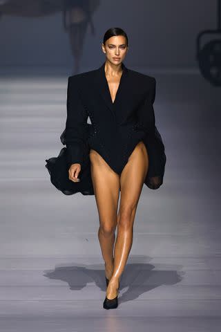 <p>Estrop/Getty</p> Irina Shayk walks the runway during Mugler's Spring 2024 show.